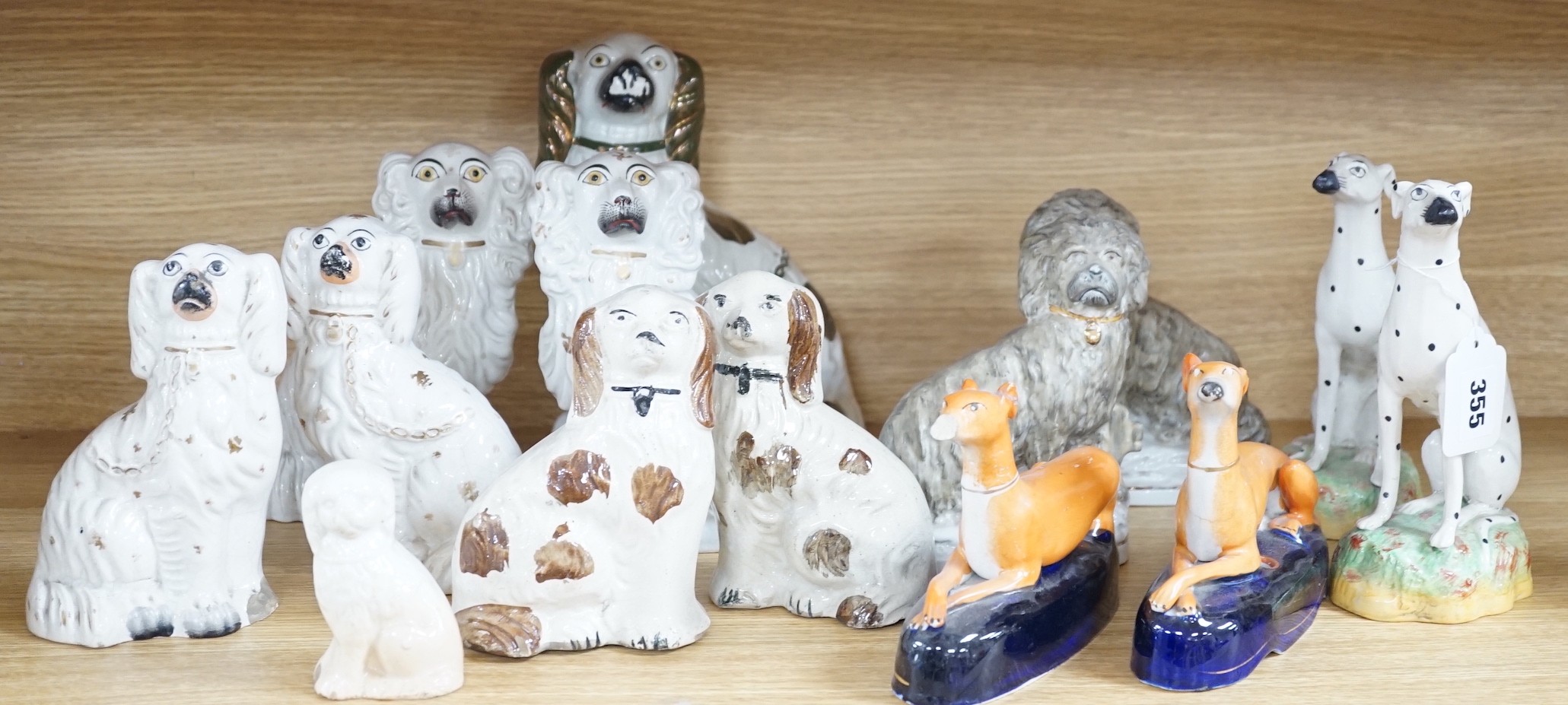 A mixed collection of mostly Staffordshire pottery models of recumbent dogs, hounds, etc. to include Dalmatians- 19.5cms high